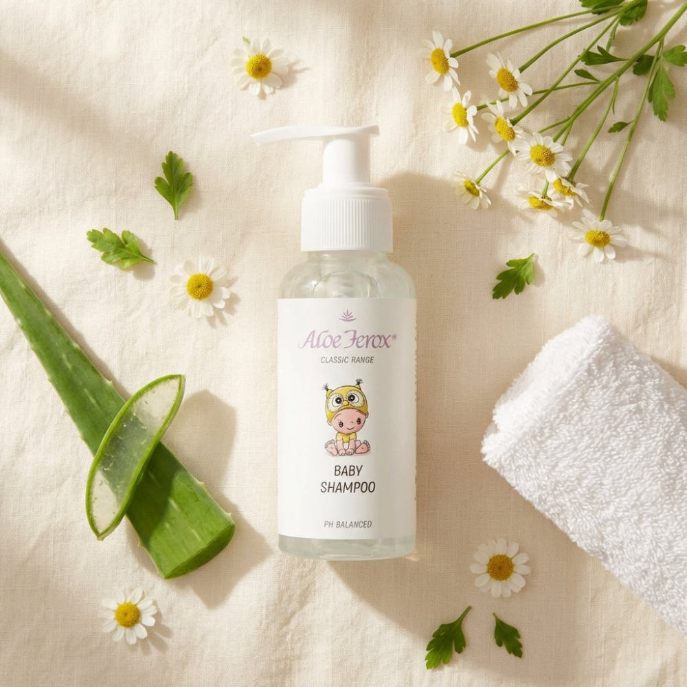 Baby shampoo bottle with aloe ferox leaf, flowers, and towel on a light background