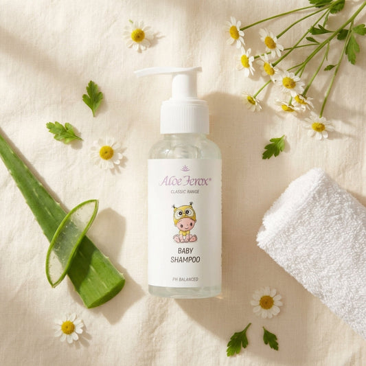Baby shampoo bottle with aloe ferox leaf, flowers, and towel on a light background