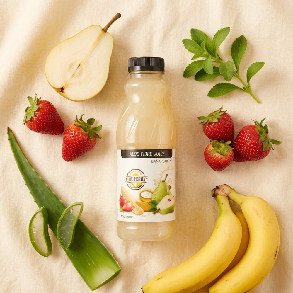 Bottle of aloe ferox juice surrounded by fruits and vegetables on a beige background
