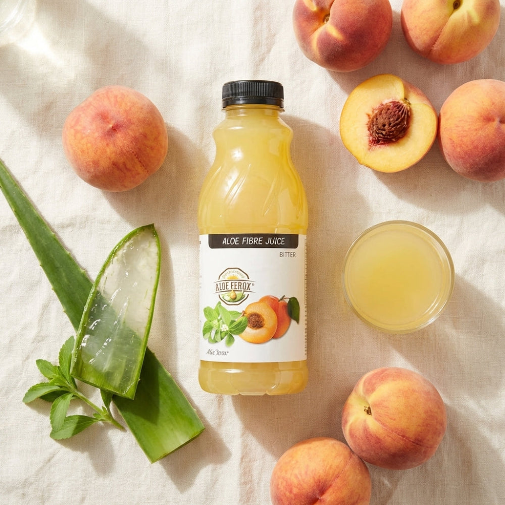 Bottle of aloe ferox juice with peaches and aloe ferox on a light background