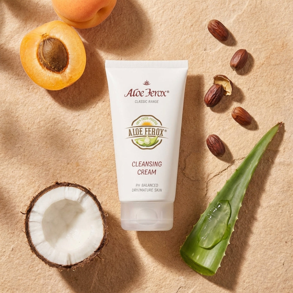 Aloe Ferox cleansing cream tube with aloe ferox leaf, coconut, and apricots on a beige background