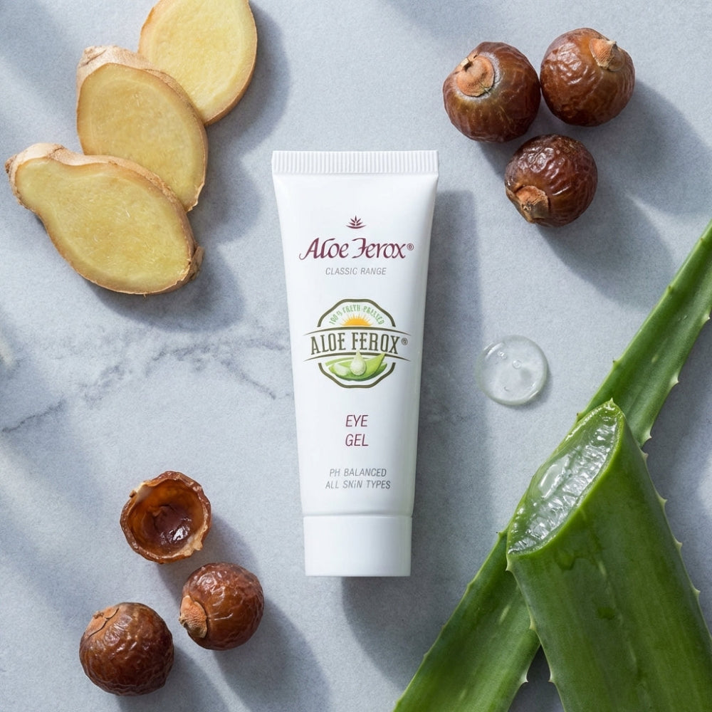 Aloe Ferox eye gel tube with aloe ferox leaves and shea nuts on a marble surface
