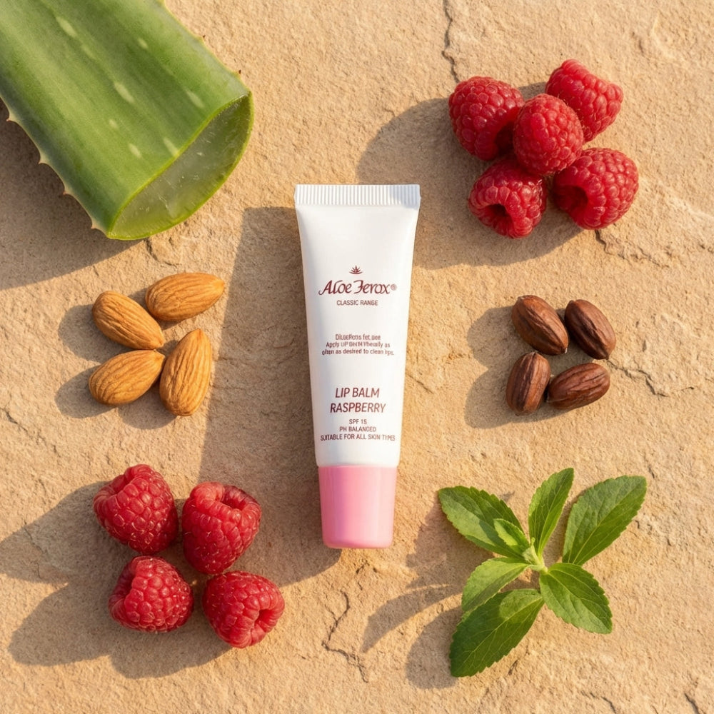 Lip balm tube with raspberry flavor surrounded by raspberries, almonds, and aloe ferox leaf on a beige background