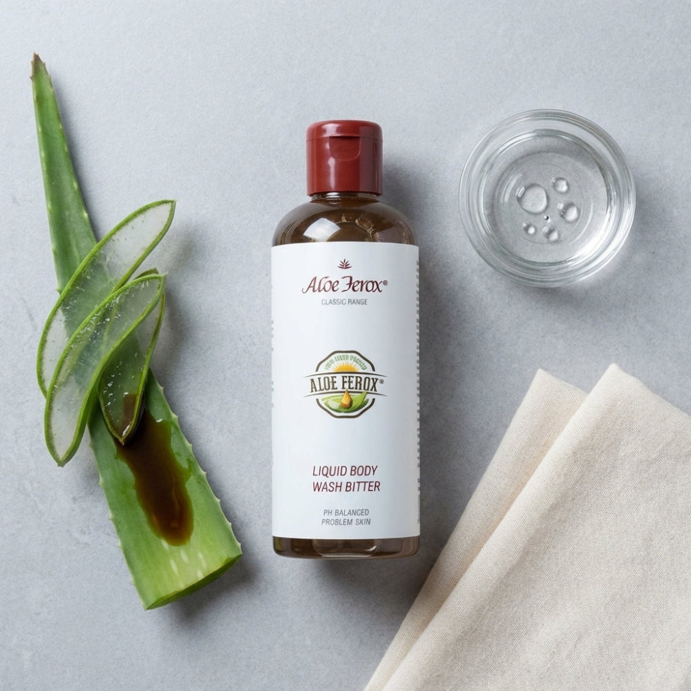A bottle of Aloe Ferox Liquid Body Wash Bitter with aloe ferox leaves on a gray background