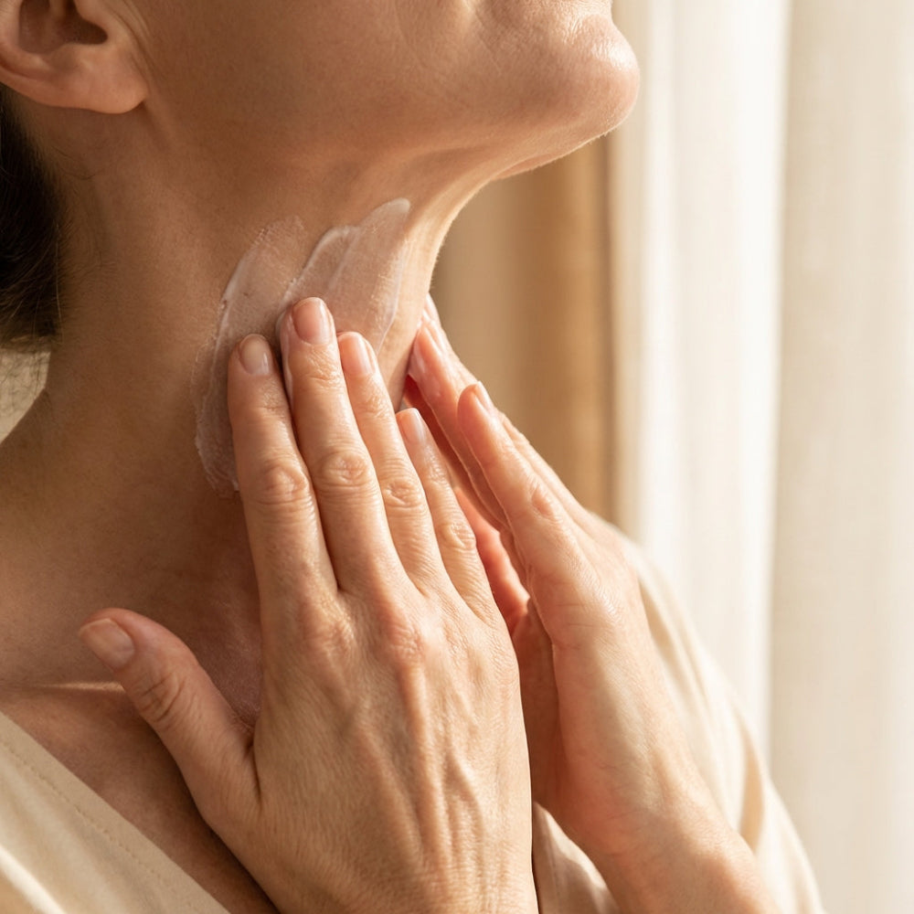 Close-up of a person applying a skincare product to their neck.
