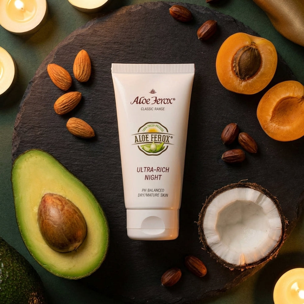 Aloe Ferox ultra-rich night cream on a dark surface with avocados, almonds, and apricots.